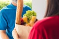 Delivery man wear protective face mask making grocery giving fresh food to woman customer Royalty Free Stock Photo