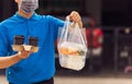 Delivery man wearing face mask making grocery giving rice food boxes plastic bags and coffee at front house