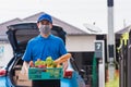 Delivery man wearing face mask protect he delivering fresh food vegetable in plastic box