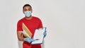 Delivery man wearing face mask and protective gloves holding parcels and envelopes, showing form for signing on Royalty Free Stock Photo