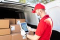 Rear view of a delivery man scanning the barcode of a package Royalty Free Stock Photo