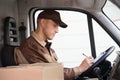 Delivery Man Writing On Clipboard In Truck Royalty Free Stock Photo