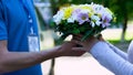 Delivery man giving bouquet to woman, easy order and delivery of flowers service