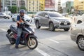 A delivery motorbike taxi man is ridding a motor cycle on busy s
