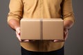 Hands of a young male delivery man with a cardboard box close-up. Royalty Free Stock Photo