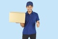 Delivery service concept. Delivery man holding box and showing like on blue background