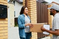 Delivery Service. Courier Delivering Package To Woman At Home. Royalty Free Stock Photo