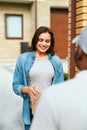 Delivery Service. Courier Delivering Package To Woman At Home. Royalty Free Stock Photo