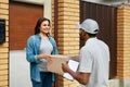 Delivery Service. Courier Delivering Package To Woman At Home. Royalty Free Stock Photo