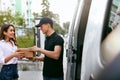 Delivery Service. Courier Delivering Package To Woman Near Car Royalty Free Stock Photo