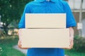 Delivery service courier standing in front of the house with boxes Royalty Free Stock Photo