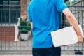 Delivery service courier standing in front of the house with box Royalty Free Stock Photo