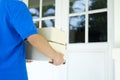 Delivery service courier standing in front of the house. Royalty Free Stock Photo