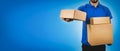 delivery service man holding cardboard boxes on blue background Royalty Free Stock Photo