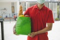 Delivery service man with protection face mask in blue uniform holding fresh food set bag for customer Royalty Free Stock Photo
