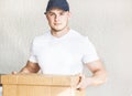 Delivery strong, muscular man loading cardboard boxes for moving to an apartment. professional worker of transportation