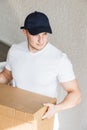 Delivery strong, muscular man loading cardboard boxes for moving to an apartment. professional worker of transportation