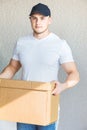 Delivery strong, muscular man loading cardboard boxes for moving to an apartment. professional worker of transportation