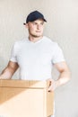 Delivery strong, muscular man loading cardboard boxes for moving to an apartment. professional worker of transportation