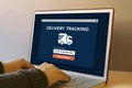 Delivery tracking concept on laptop computer screen on wooden ta