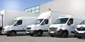 Delivery white vans in service van trucks and cars in front of the entrance of a warehouse distribution logistic Royalty Free Stock Photo
