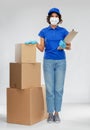 Delivery woman in mask with boxes and clipboard