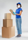 Delivery woman in mask with boxes and clipboard