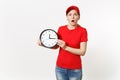 Delivery woman in red uniform isolated on white background. Shocked late female in cap, t-shirt, jeans working as Royalty Free Stock Photo