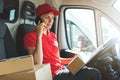 Delivery woman talking on mobile phone in van