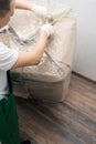 Delivery worker opens a box with a delivered cargo with a knife, top view