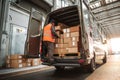 Delivery worker organizing boxes in back of cargo van Royalty Free Stock Photo