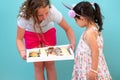 Delivery young woman, cute teenage girl with freckles delivering to home the diverse sweets in a white box. Royalty Free Stock Photo