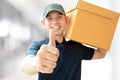 Deliveryman carrying a box, giving thumbs up