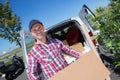 Deliveryman carrying cardboard parcel box in front delivery