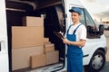 Deliveryman in uniform, carton boxes in the car Royalty Free Stock Photo