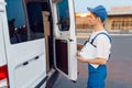 Deliveryman in uniform closing the car, delivering Royalty Free Stock Photo