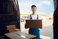 Deliveryman unloads the car with parcels, delivery