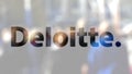 Deloitte logo on a glass against blurred crowd on the steet. Editorial 3D rendering Royalty Free Stock Photo