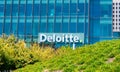 Deloitte logo is seen above green landscaping on company office downtown