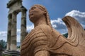 The famous Sphinx of Naxos preserved in the Archaeological Museum of Delphi against the backdrop of the Temple of Athena