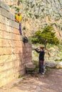 Archeologists at work - Man lowers rubber bucket of dirt down a wall for a woman to put into wheel