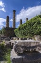 Temple of Apollo and a Ionic order capital of an ancient column at the archaeological site of Delphi. Royalty Free Stock Photo
