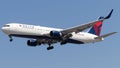 Delta airlines aircraft soaring against a blue sky backdrop.