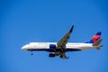 Delta Connection Embraer E175LR aircraft operated by SkyWest Airlines preparing for landing at airport with deployed landing gear