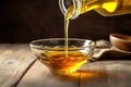 The Art of Cooking: Pouring Cooking Oil from a Jug into a Bowl on a Wooden Table