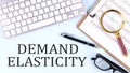 DEMAND ELASTICITY text on blue background with keyboard and clipboard, business concept Royalty Free Stock Photo