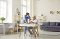 Nurse in retirement home helping senior man who is sitting at desk and doing puzzles