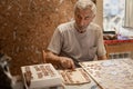 Dementia prevention. Elderly man hands doing jigsaw puzzle Royalty Free Stock Photo