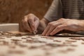 Dementia prevention. Elderly man hands doing jigsaw puzzle at home Royalty Free Stock Photo