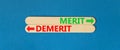 Demerit or merit symbol. Concept word Demerit or Merit on beautiful wooden stick. Beautiful blue table blue background. Business